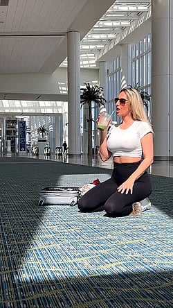 Sunny day, sunny drink: A hot girl sips on a cold beverage in a sunny spot.'